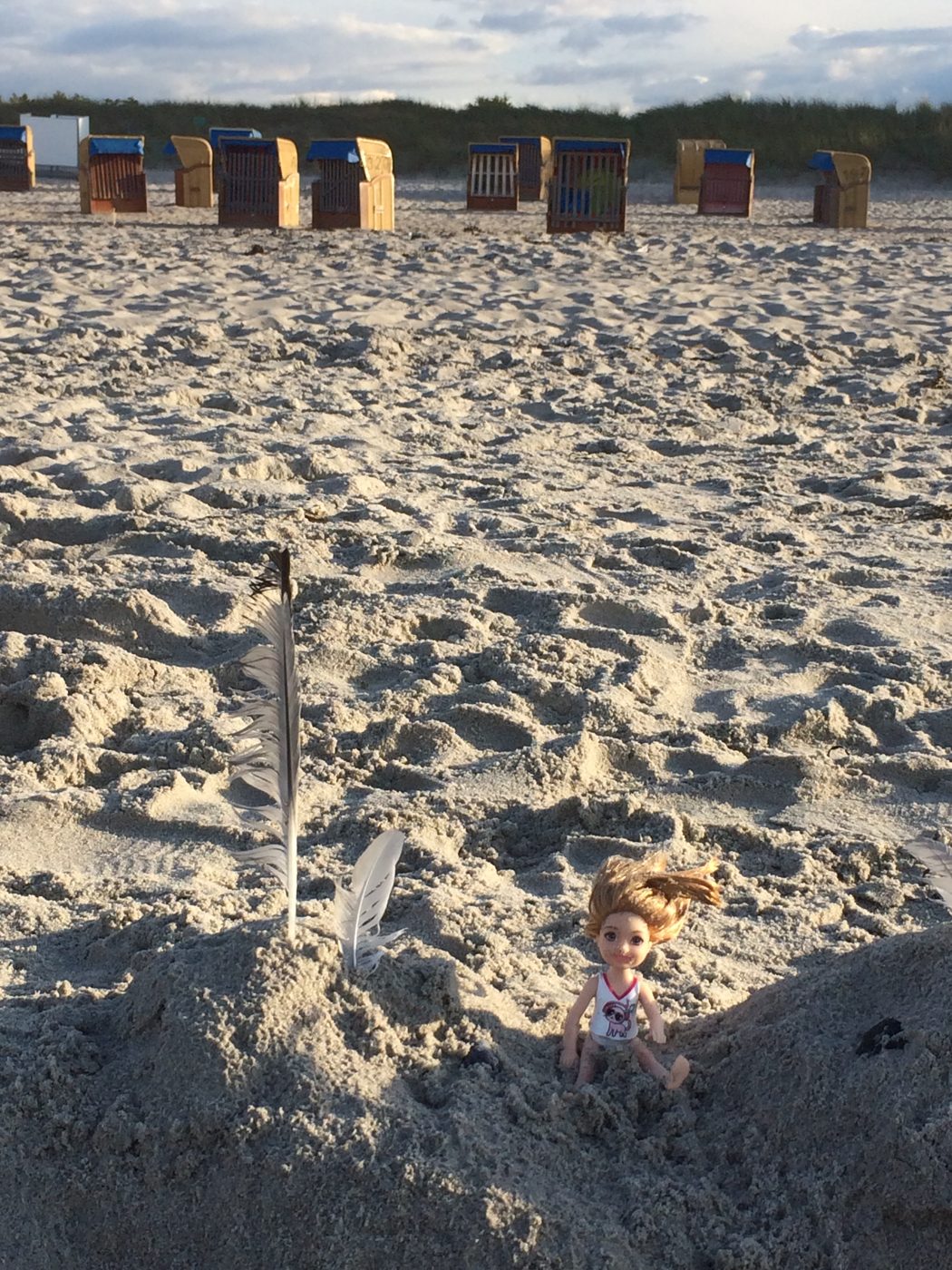 Strandkörbe und Federn im Sand an der Ostsee